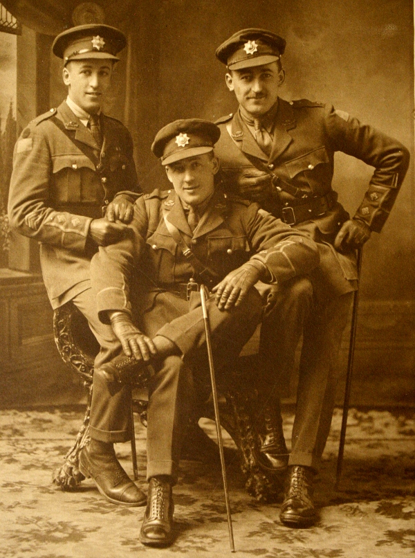 A studio photograph of three officers of The Royal Canadian Regiment: brothers Lieut. Rupert Murray Millett, MC, Lieut. Frederick Brenton Millett, MC, and Lieut. John Stanley Millett.